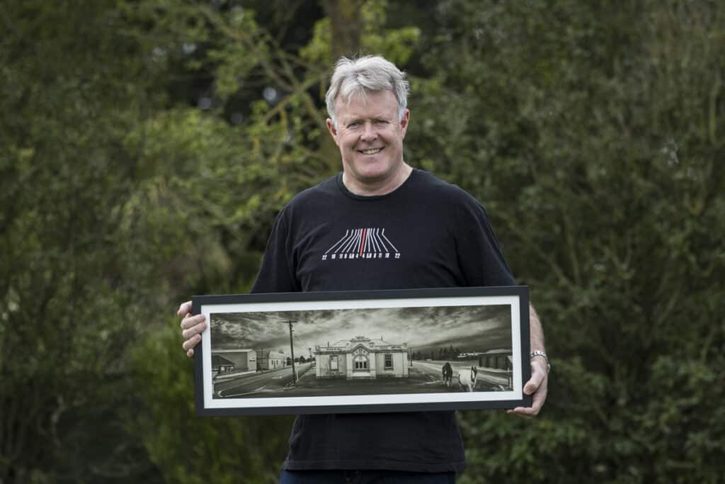 NZIPP Grand Master Tony Stewart holds fine art print made by Queensberry.