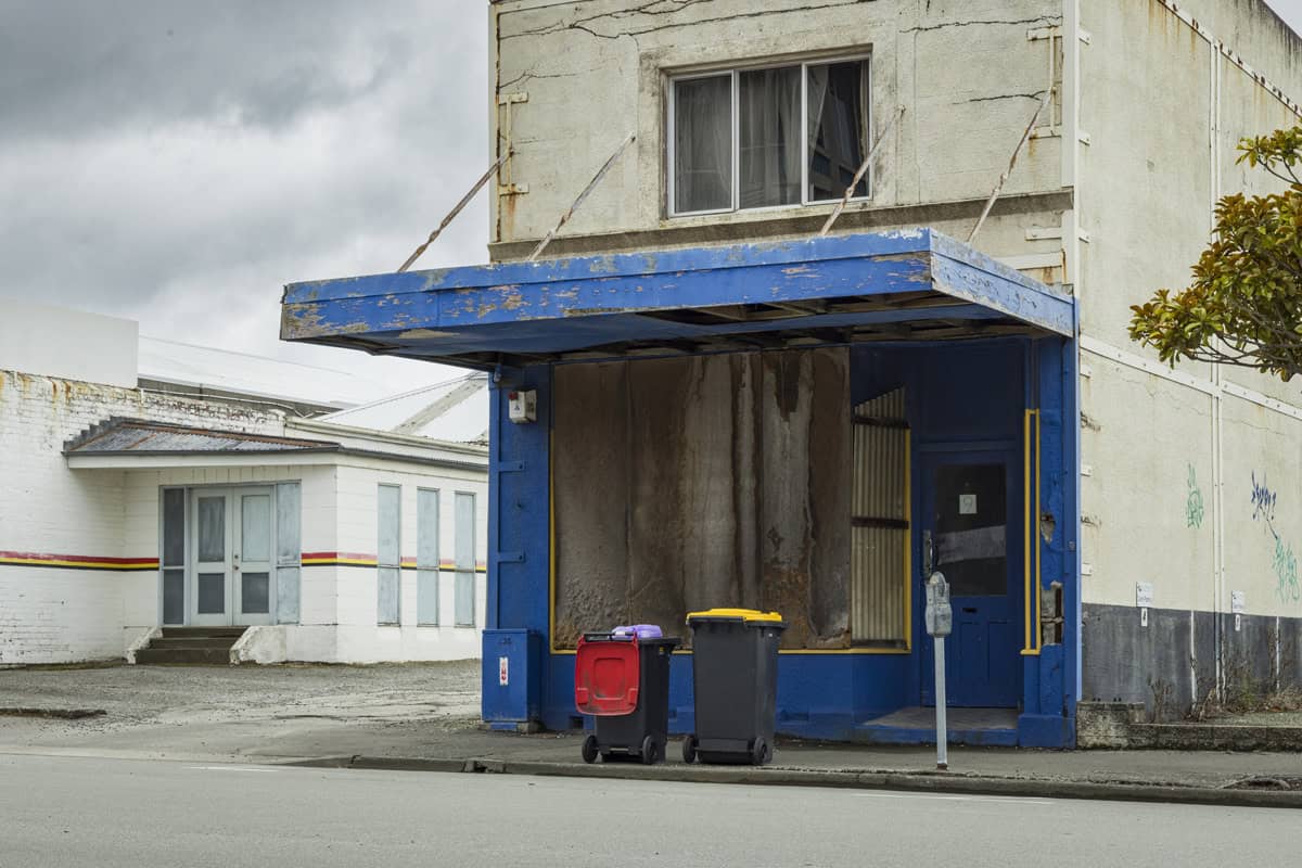 Shop closed up during Christmas holiday period, but with rubbish bins out for collection.