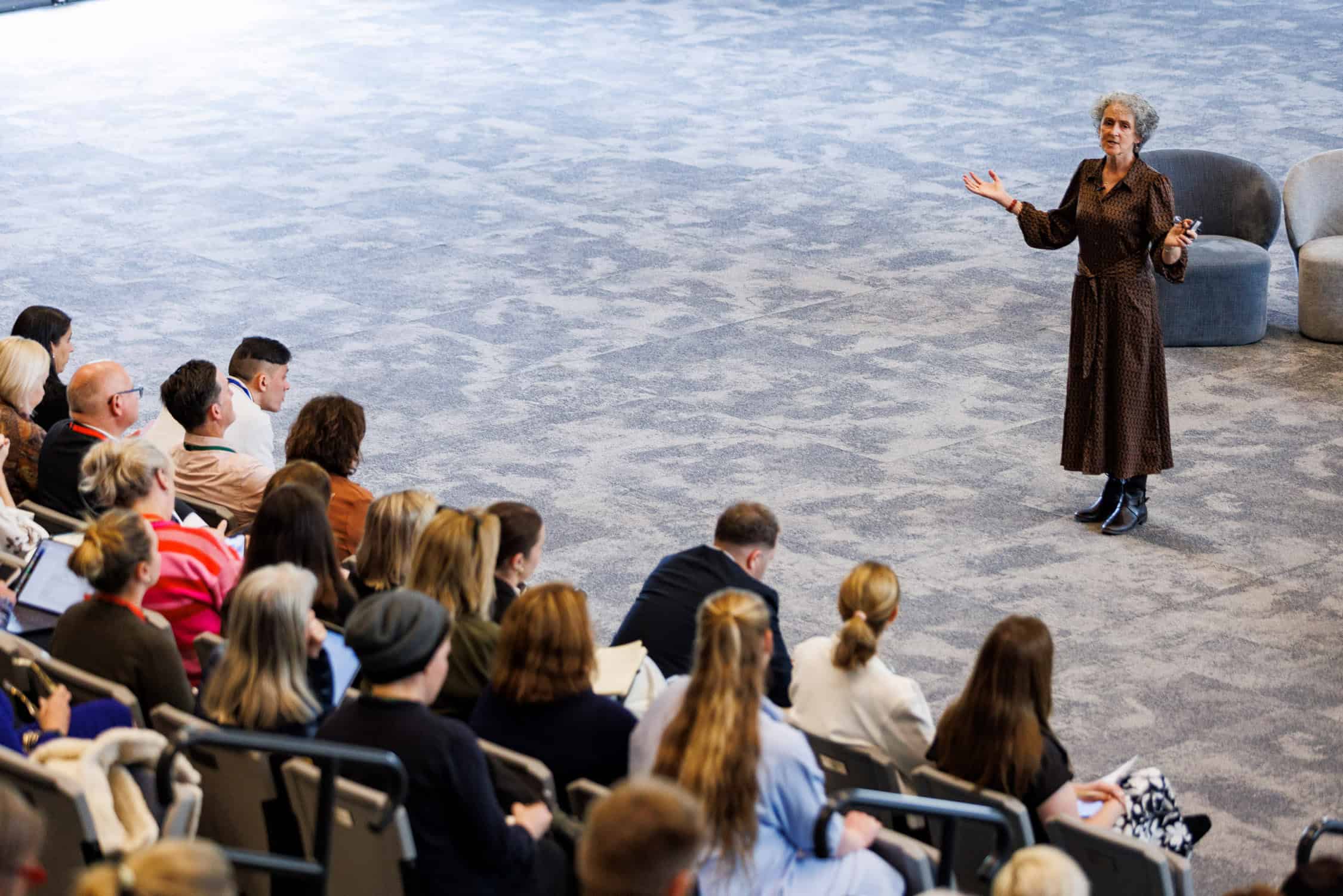 Keynote speaker delivers to group of delegates seated at conference, Rangi Ruru gymnasium.