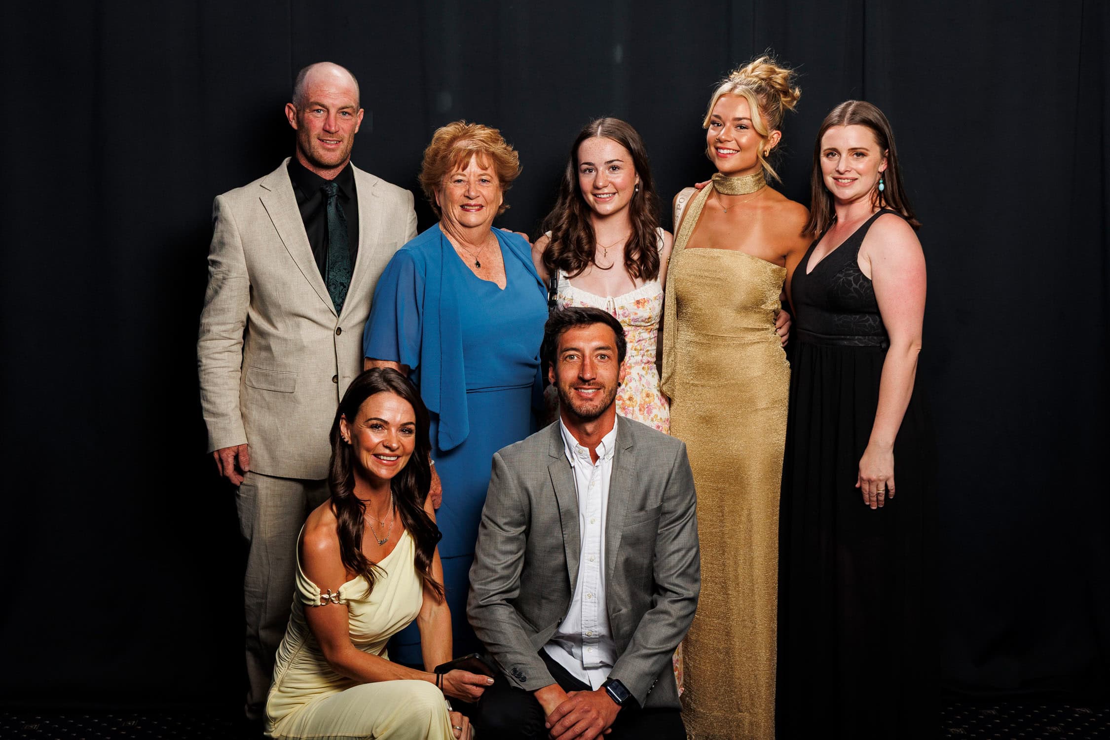 Family group pose at a student graduation dinner.